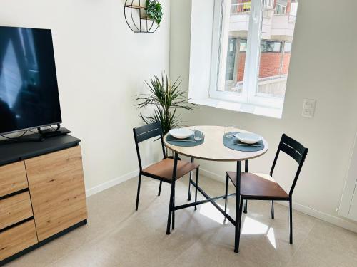 a dining room with a table and chairs and a tv at The Urban Suite - Stylish and with FREE parking in Lugano