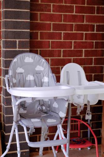 two white chairs sitting next to a brick wall at Homely Retreat-4 Minutes from Pacific Werribee Shopping Centre in Werribee