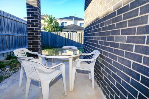 a table and chairs sitting next to a brick wall at Homely Retreat-4 Minutes from Pacific Werribee Shopping Centre in Werribee