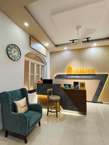 a lobby with a sunrider store with a chair and a clock at Summer Hotel in Dĩ An