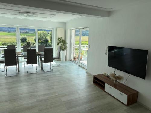 a living room with a television and a table with chairs at Haus an der Weser Ferienwohnung in Brevörde