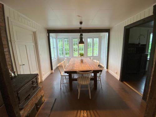 a dining room with a wooden table and chairs at Cozy white house close to the nature with Wi-Fi 