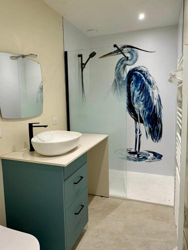 a bathroom with a blue bird painting on the wall at La petite Madeleine de Chavignol in Sancerre