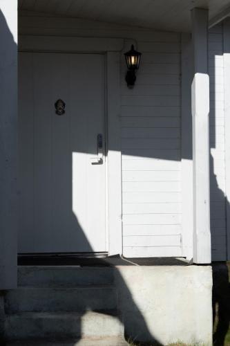 a white door of a house with a light on it at Cozy white house close to the nature with Wi-Fi 