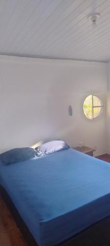a blue bed in a room with a window at Guest House in Petrópolis in Petrópolis