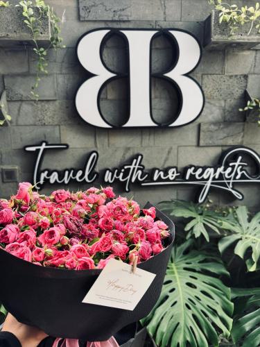 a large bowl of pink roses in front of a sign at Ben Ben Hotel - Near City Center - Budget Stay in Da Lat