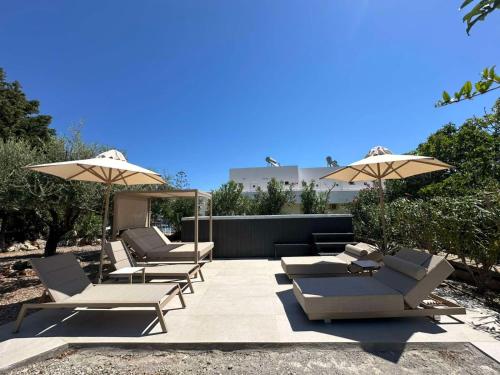 a group of chairs and umbrellas on a patio at Le Soleil De Lindos - Luxury Villa with Swim Spa in Líndos