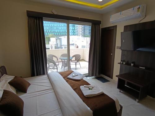 a hotel room with a bed and a balcony with a table at Hotel Legacy Grand - Rooms & Suites - Near AIG Hospital in Hyderabad