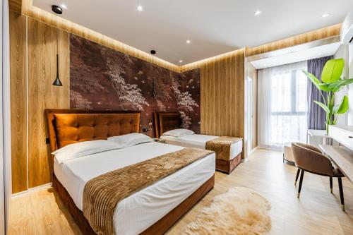 a hotel room with two beds and a desk at Hotel Villa Verona in Durrës