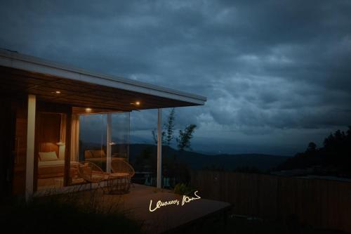 a house with a balcony with a view of the mountains at บ้านละอองฟ้า1 แอร์ ม่อนแจ่ม วิวดอยหลวงเชียงดาว in Mon Jam