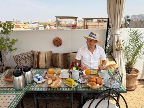 Una donna seduta a un tavolo con sopra del cibo di Riad Mouna a Marrakech