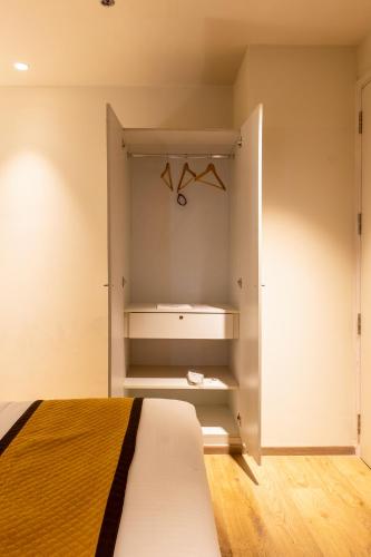 a bedroom with a bed and a closet at The Trot Hotel & Suites near Yashobhoomi Udyog vihar in Gurgaon