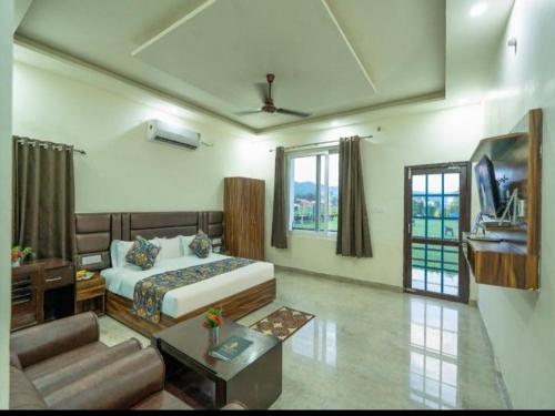 a bedroom with a bed and a living room at Eiyuu Hotels - Wildlife & Nature Vista in Jhirna