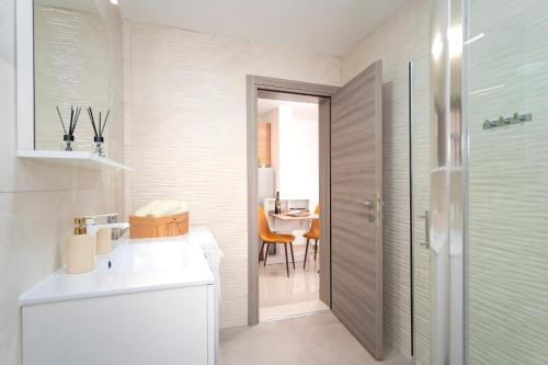 a bathroom with a shower and a sink and a table at Guest House Marinna in Vrboska