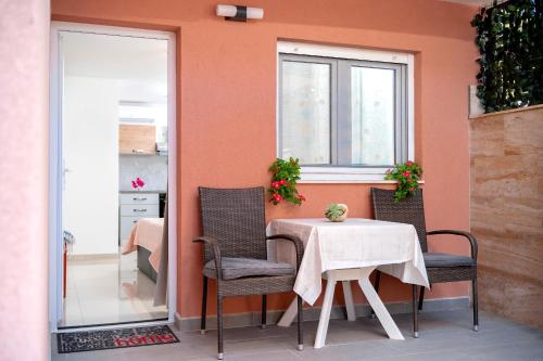 a table and chairs in a room with a window at Guest House Marinna in Vrboska
