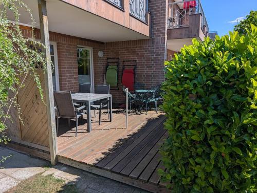 a wooden deck with a table and chairs on a house at Ferienwohnung in Boltenhagen in Boltenhagen