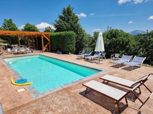 a pool with chairs and a table and a frisbee at BnB Bagno di Bosco in Gubbio