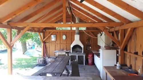 a large wooden pavilion with a table and an oven at Chalupa u Kahounů in Popovice
