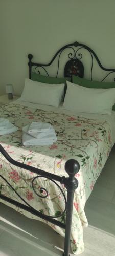 a bed with a floral comforter and pillows at G&D House in Latina