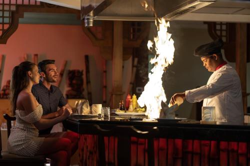 a man standing in a kitchen with a chef preparing food at Jolie Ville Hotel & Spa Kings Island Luxor in Luxor