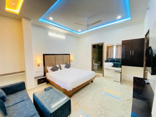 Un dormitorio con una cama y una sala de estar. en Hotel Shreenath Kathiyawadi And Pure Veg Kathiyawadi Restaurant Udaipur, en Udaipur