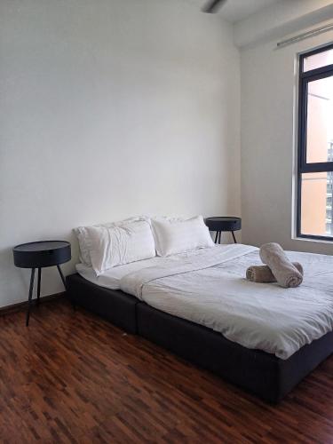 a bedroom with a bed with two tables and a window at Family Friendly Unit in K Avenue in Donggongon