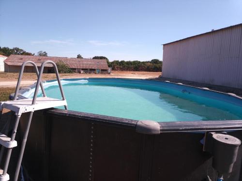 una piscina con una sedia sopra di Camping les Petites Roches a Corme-Royal