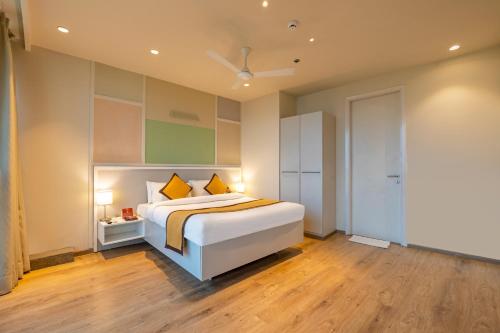 a bedroom with a large bed with yellow pillows at The Trot Hotel & Suites near Yashobhoomi Udyog vihar in Gurgaon