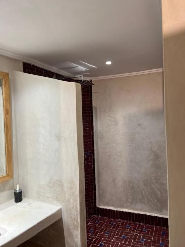 a bathroom with a shower and a large window at Medina social club in Fès
