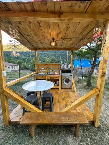 a wooden cabin with a table and a stove at HOMELAND in Mestia