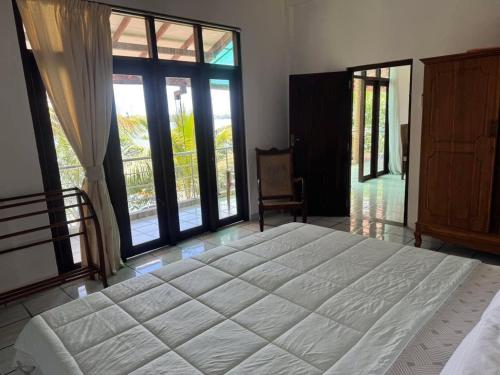 Un dormitorio con una cama grande y grandes ventanales. en Aqua Leisure Resort Bentota, en Bentota