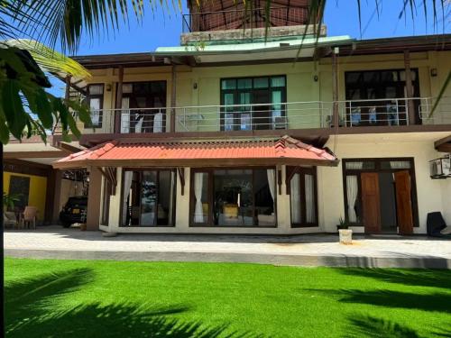 Un edificio con un césped verde delante. en Aqua Leisure Resort Bentota, en Bentota