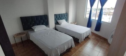 a small bedroom with two beds and a window at Hospedarte Cali Sur in Cali
