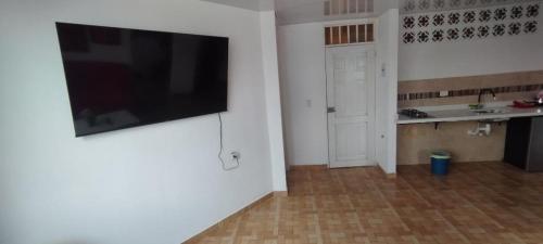 a living room with a flat screen tv hanging on a wall at Hospedarte Cali Sur in Cali