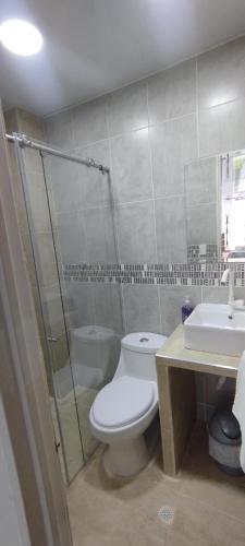 a bathroom with a toilet and a shower and a sink at Hospedarte Cali Sur in Cali