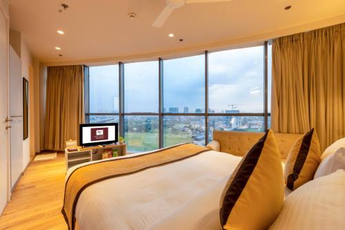 a hotel room with a bed and a television at The Trot Hotel & Suites near Yashobhoomi Udyog vihar in Gurgaon