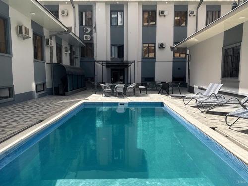 a swimming pool in front of a building at Grand Zamin Hotel in Tashkent