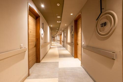 a corridor of a hallway with wooden doors at The Trot Hotel & Suites near Yashobhoomi Udyog vihar in Gurgaon