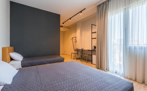 a bedroom with a bed and a large window at Doors Boutique Hotel in Tbilisi City
