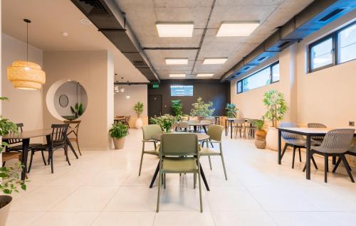 a dining room with tables and chairs and potted plants at Doors Boutique Hotel in Tbilisi City