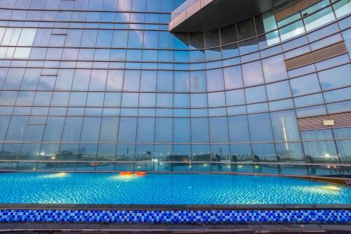 a swimming pool in the side of a building at The Trot Hotel & Suites near Yashobhoomi Udyog vihar in Gurgaon