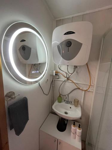 a bathroom with a white sink and a mirror at Maya Vendégház in Bogács
