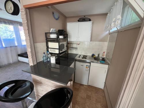 a small kitchen with black chairs and a counter at Maya Vendégház in Bogács