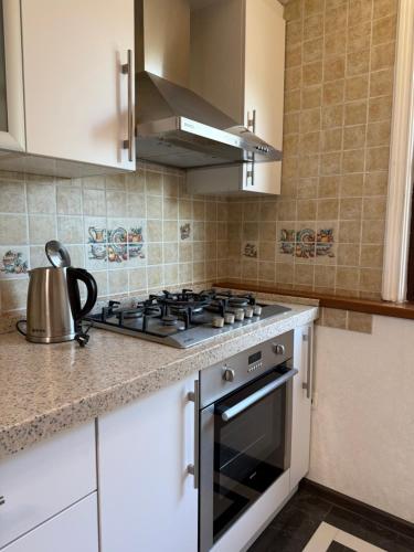 a kitchen with a stove top oven in a kitchen at CHEKHOV APARTMENT in Tashkent