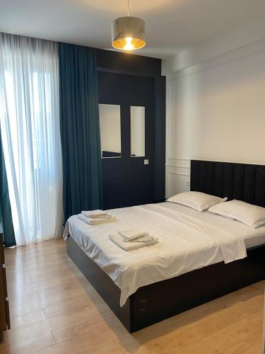 Cozy Apartment For Daily Rent في تبليسي: غرفة نوم بها سرير كبير مع مناشف عليه