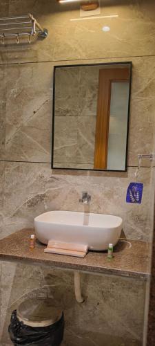 a bathroom sink with a mirror on a counter at Hotel Shlok Inn in Somnath