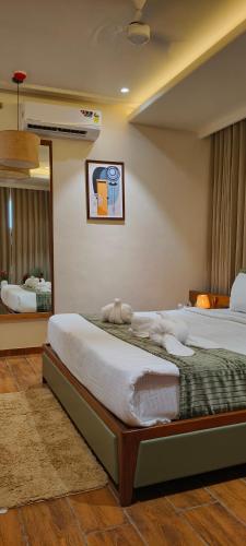 a bedroom with a large bed and a mirror at Hotel Shlok Inn in Somnath