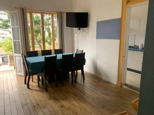 une salle à manger avec une table et des chaises bleues dans l'établissement Mi hogar de Flores - A pasos del Estadio Elias Figueroa y mirador 21 de Mayo, à Valparaíso