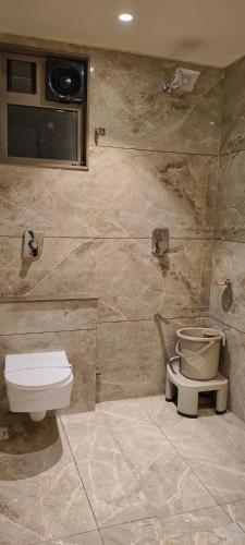 a bathroom with a toilet and a sink at Hotel Shlok Inn in Somnath