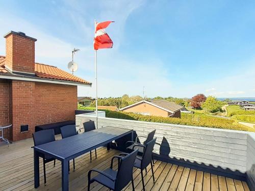 a blue table and chairs on a deck with a flag at 10 person holiday home in Roslev in Flovtrup